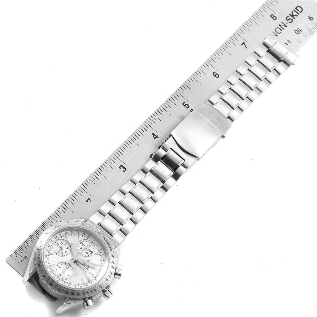 The image shows an Omega Speedmaster 3221.30.00 Men's Stainless Steel Silver Dial 3221.30.00 Men's Stainless Steel Silver Dial watch laid flat, displaying the face and metal bracelet alongside a ruler for scale.