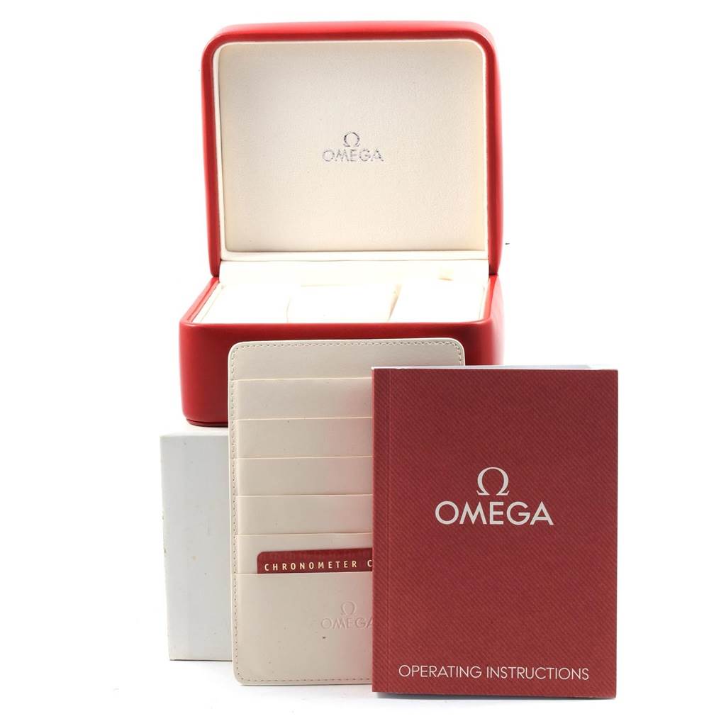 The image shows the packaging and accessories of an Omega Speedmaster 3221.30.00 Men's Stainless Steel Silver Dial 3221.30.00 Men's Stainless Steel Silver Dial, including a red box, instruction manual, and card holder.