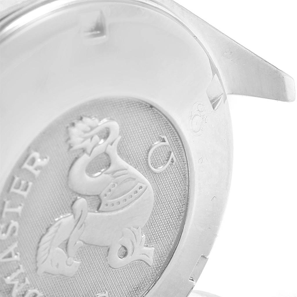 The image shows the case back of an Omega Speedmaster 3212.80.00 Men
s Stainless Steel Blue Dial 3212.80.00 Men
s Stainless Steel Blue Dial watch, highlighting the engraved emblem and lettering.