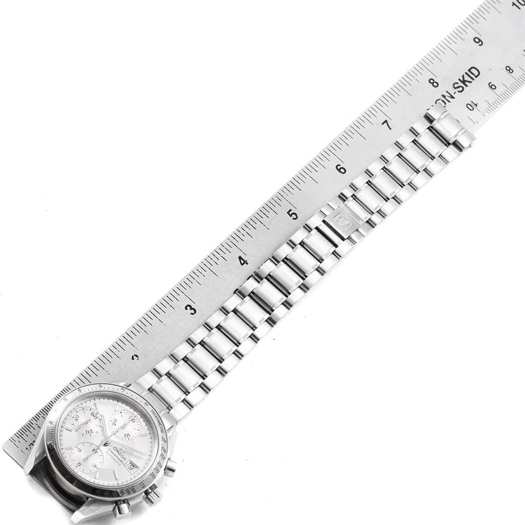 The Omega Speedmaster 3513.30.00 Men
s Stainless Steel Silver Dial 3513.30.00 Men
s Stainless Steel Silver Dial watch is shown from an overhead angle, highlighting the face, case, and bracelet next to a ruler for scale.