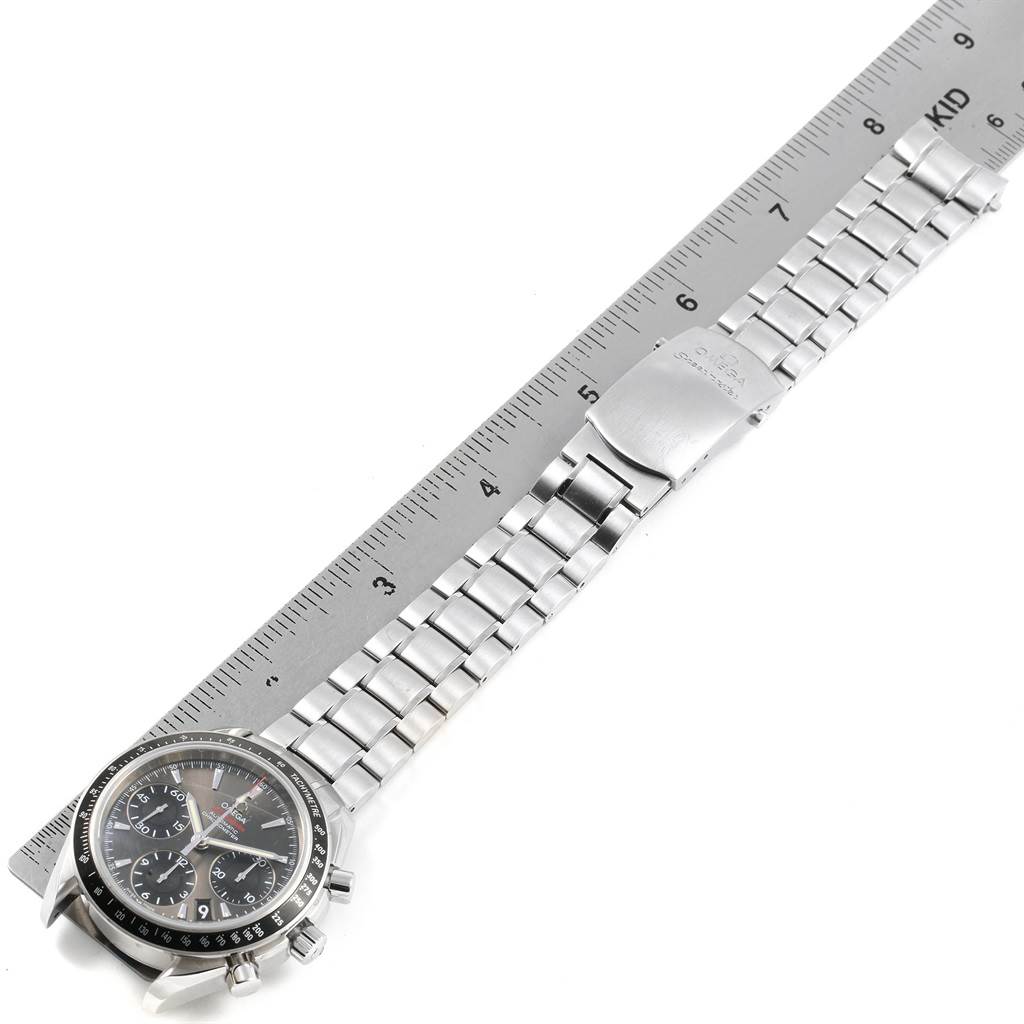 This image shows an Omega Speedmaster 323.30.40.40.06.001 Men's Stainless Steel Grey Dial 323.30.40.40.06.001 Men's Stainless Steel Grey Dial watch lying flat, highlighting its face, metal bracelet, clasp, and a part of a ruler for scale.