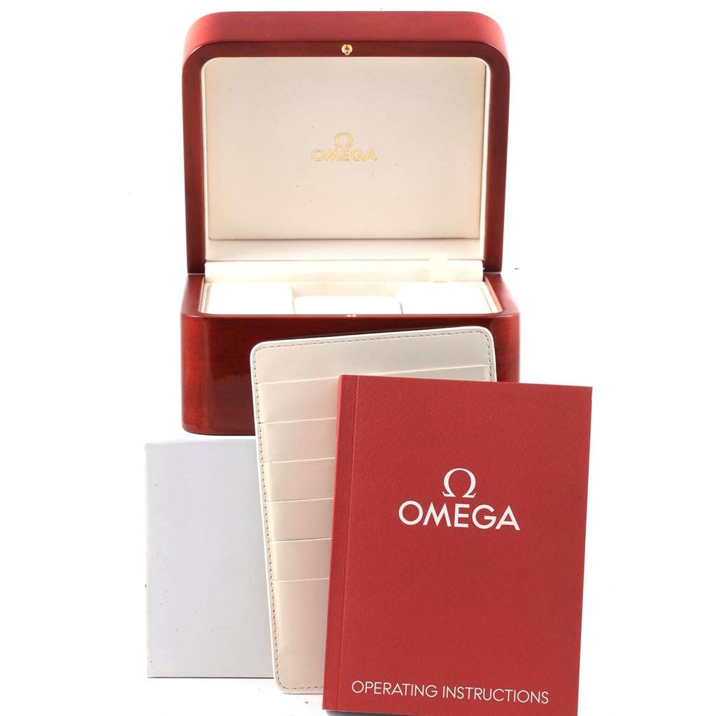 The image shows the packaging and accessories of an Omega Speedmaster 323.30.40.40.04.001 Men
s Stainless Steel White Dial 323.30.40.40.04.001 Men
s Stainless Steel White Dial, including an open watch box, a booklet, and instruction manuals.