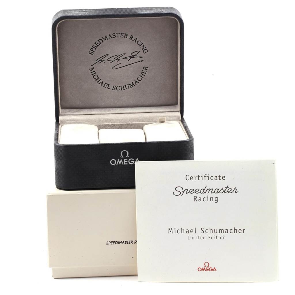 This image shows an Omega Speedmaster 3519.50.00 Men
s Stainless Steel Black Dial 3519.50.00 Men
s Stainless Steel Black Dial watch box, Michael Schumacher edition, alongside its certificate from an elevated angle.