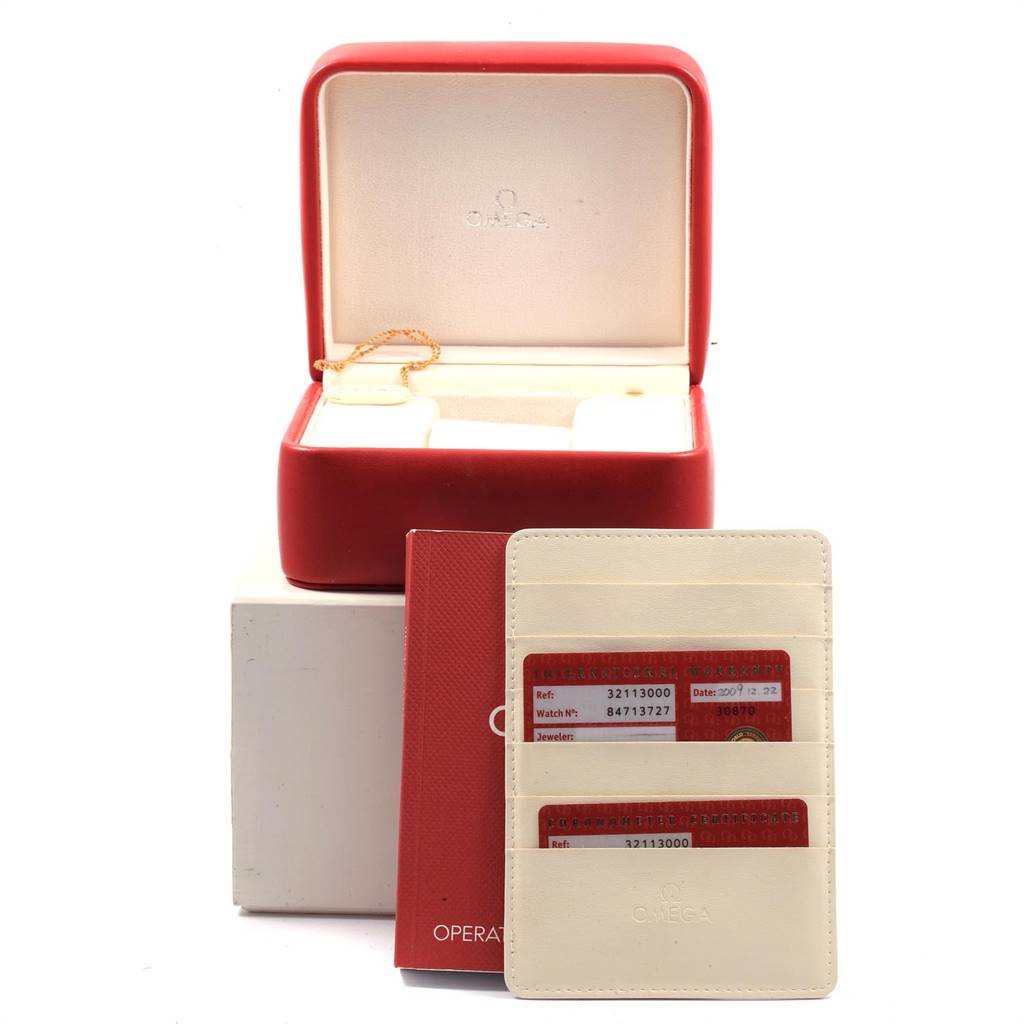 The image shows an open Omega Speedmaster 3211.30.00 Men
s Stainless Steel Silver Dial 3211.30.00 Men
s Stainless Steel Silver Dial watch box with cards and an instruction booklet displayed in front.