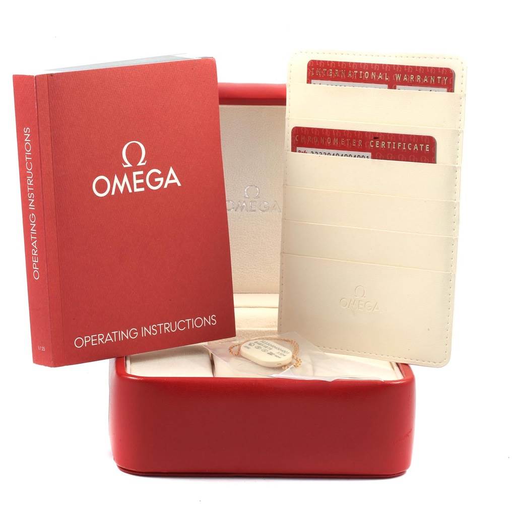 The image shows the operating instructions and warranty cards for the Omega Speedmaster 323.30.40.40.04.001 Men
s Stainless Steel White Dial 323.30.40.40.04.001 Men
s Stainless Steel White Dial watch, along with its open red case.