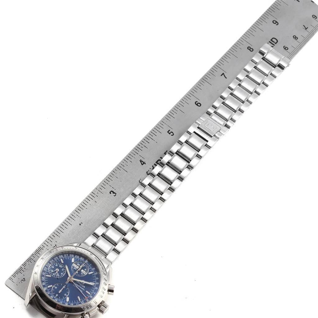 The image shows an Omega Speedmaster 3523.80.00 Men
s Stainless Steel Blue Dial 3523.80.00 Men
s Stainless Steel Blue Dial watch with a steel bracelet and part of the dial, aligned next to a ruler measuring its length.
