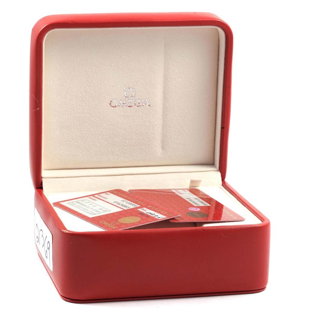 The image shows a red Omega Speedmaster 3212.80.00 Men
s Stainless Steel Blue Dial 3212.80.00 Men
s Stainless Steel Blue Dial watch box open, displaying the brand
s logo and containing documentation cards.