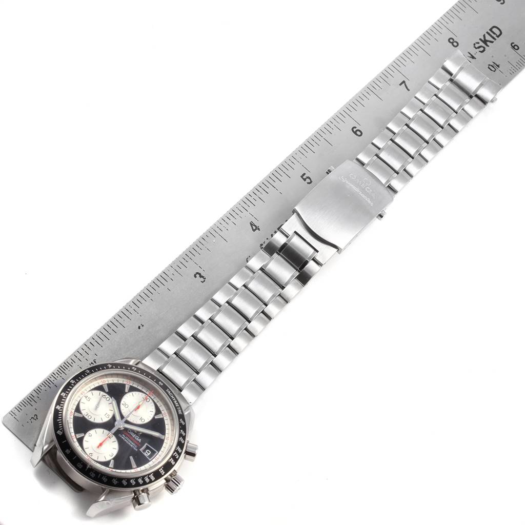 The image shows an Omega Speedmaster 3210.51.00 Men
s Stainless Steel Black Dial 3210.51.00 Men
s Stainless Steel Black Dial watch laid flat with its steel bracelet extended alongside a ruler.