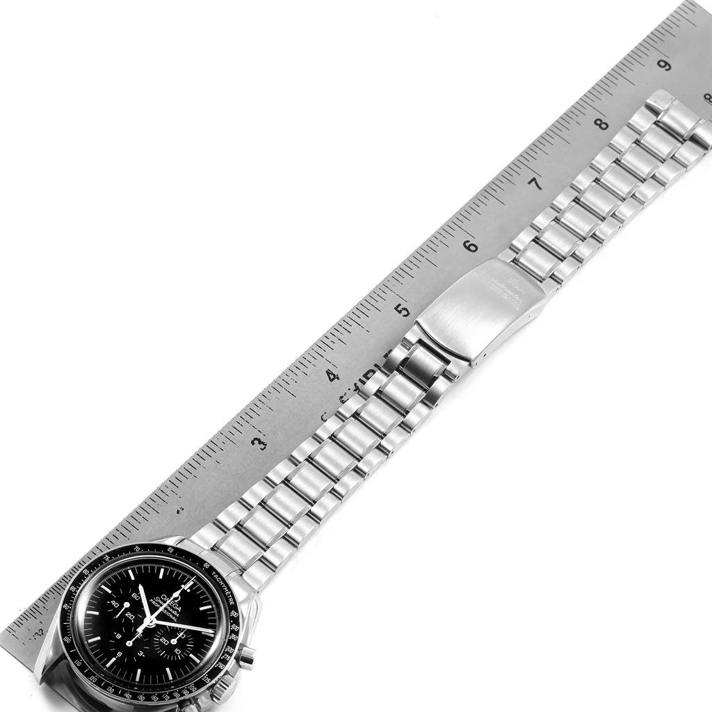 The image shows an Omega Speedmaster 3570.50.00 Men
s Stainless Steel Black Dial 3570.50.00 Men
s Stainless Steel Black Dial watch laid flat next to a ruler, displaying the watch face, bezel, and entire metal bracelet.