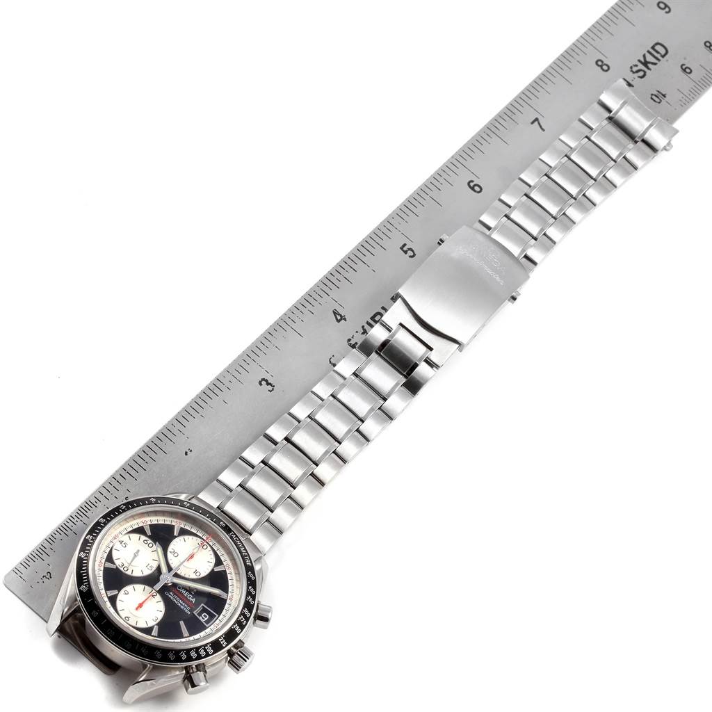 The Omega Speedmaster 3210.51.00 Men
s Stainless Steel Black Dial 3210.51.00 Men
s Stainless Steel Black Dial watch is shown from a top-down angle, displaying the face, stainless steel bracelet, and clasp alongside a ruler.