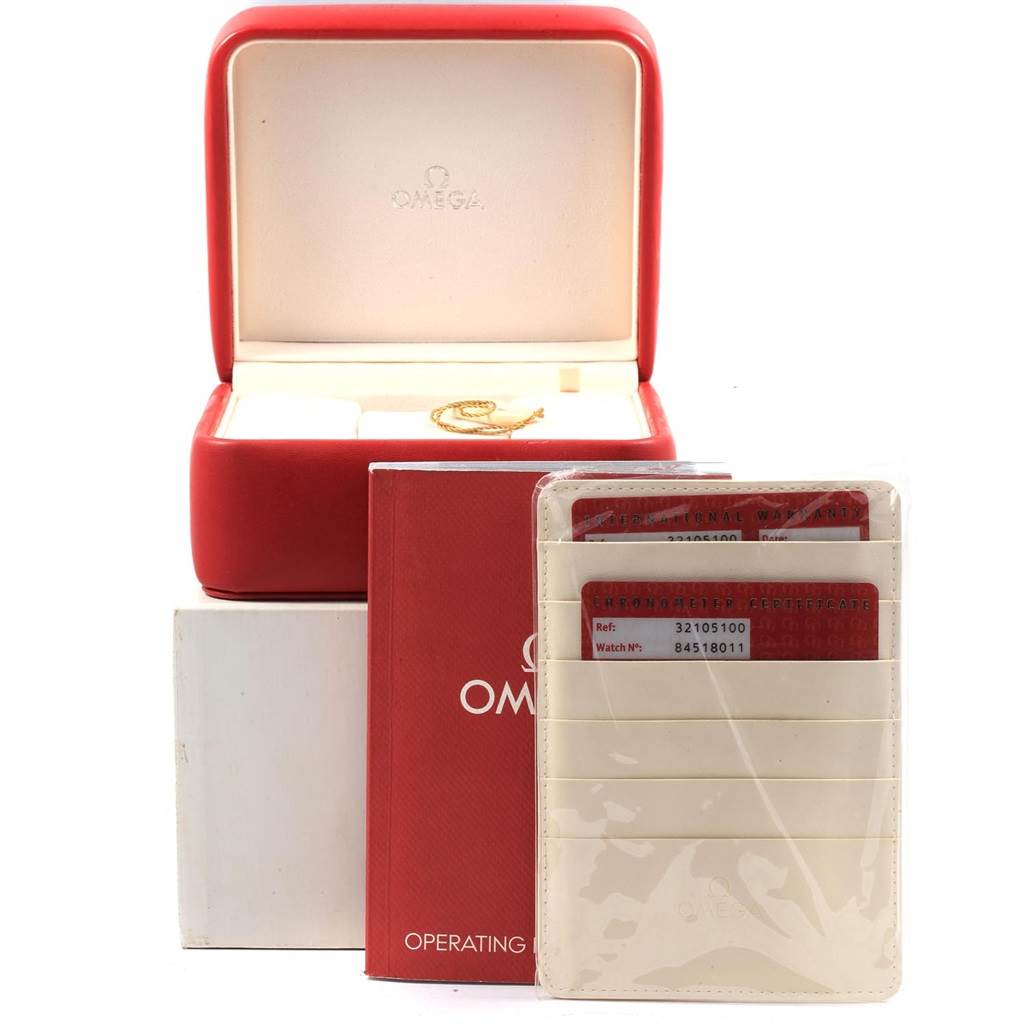 The image shows the box and documentation for the Omega Speedmaster 3210.51.00 Men
s Stainless Steel Black Dial 3210.51.00 Men
s Stainless Steel Black Dial watch, including cards, a manual, and a red watch box.