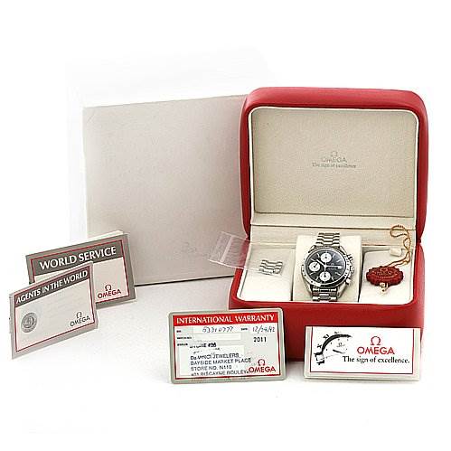 The image shows an Omega Speedmaster 3511.   50.   00 Men
s Stainless Steel Black Dial 3511.   50.   00 Men
s Stainless Steel Black Dial watch in its box, with warranty cards, a service card, extra links, and a tag.