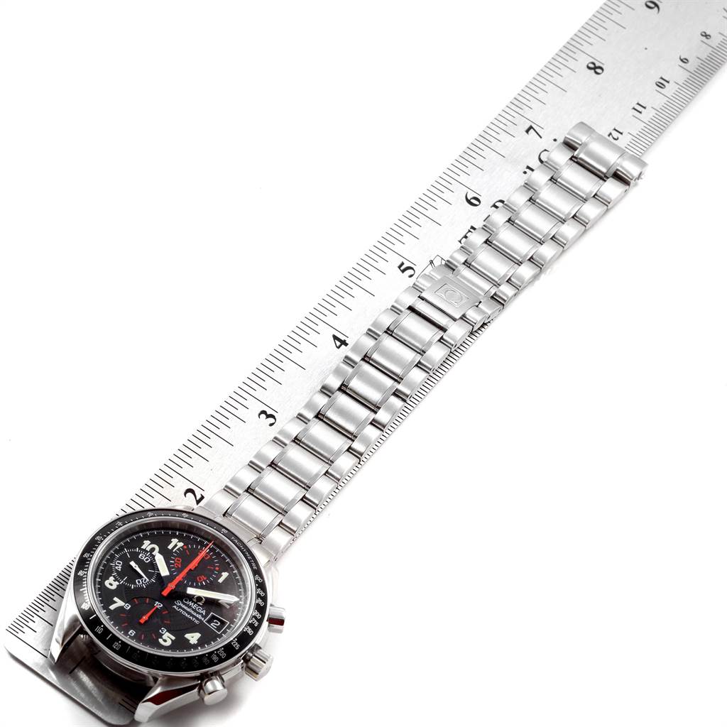 The Omega Speedmaster 3513.53.00 Men
s Stainless Steel Black Dial 3513.53.00 Men
s Stainless Steel Black Dial watch is shown from a top-down angle, displaying its face and stainless steel bracelet alongside a ruler.