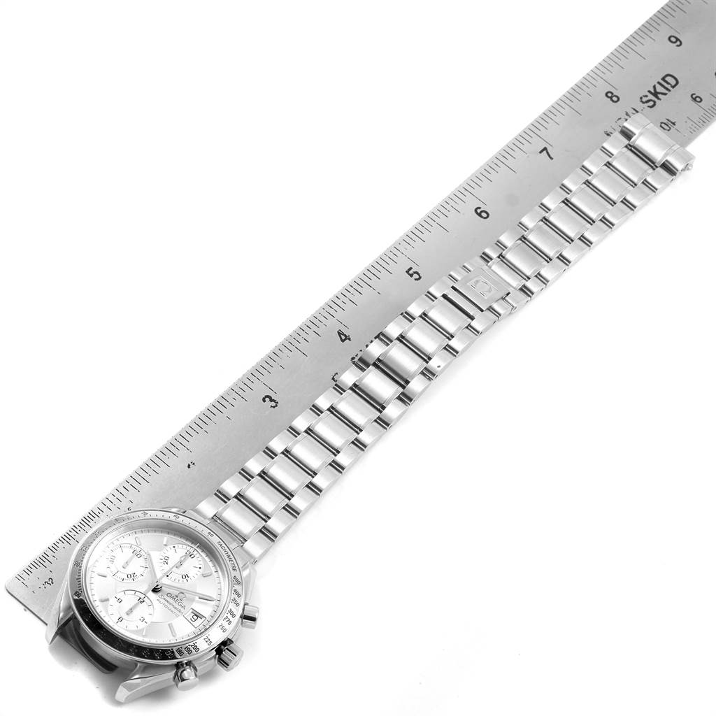 The image shows an Omega Speedmaster 3513.30.00 Men's Stainless Steel Silver Dial 3513.30.00 Men's Stainless Steel Silver Dial watch face and full metal bracelet next to a ruler, taken from a top-down angle.