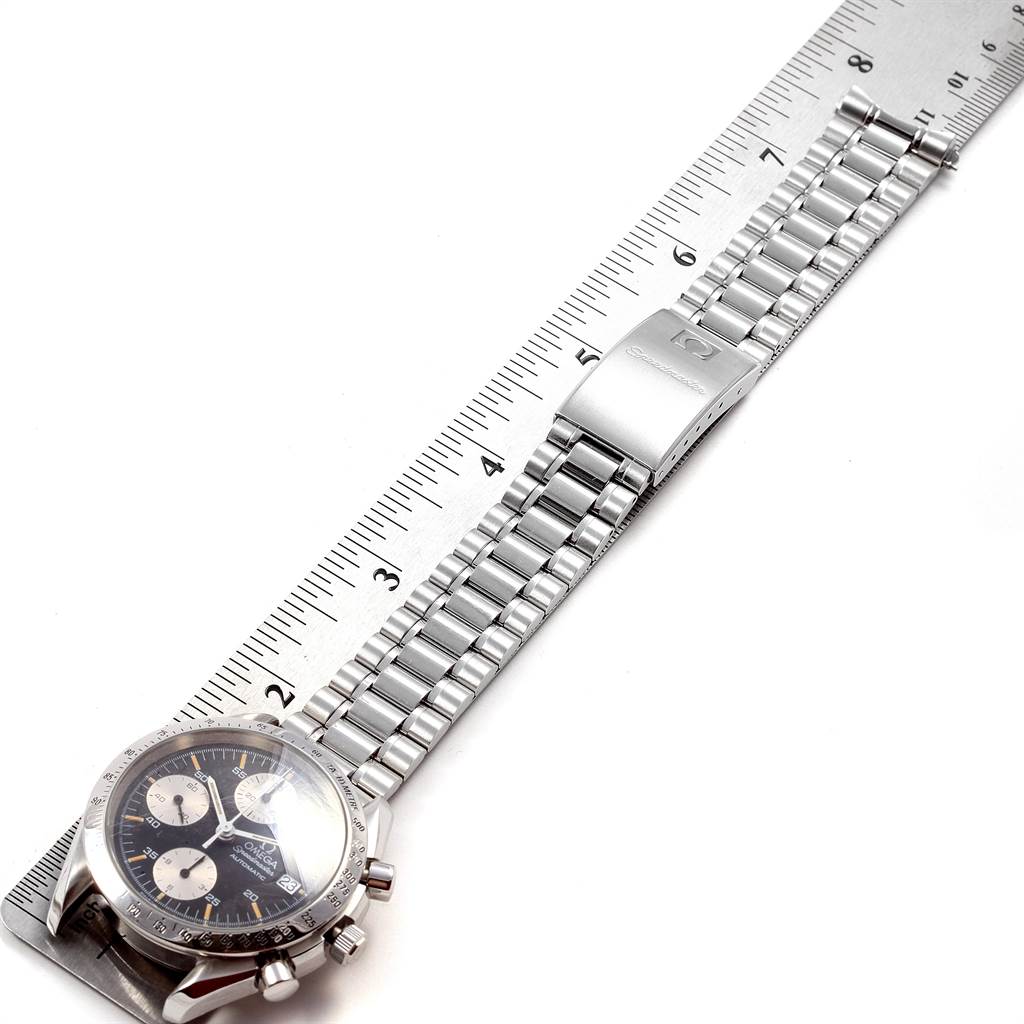 The angle shows the Omega Speedmaster 3511.50.00 Men
s Stainless Steel Black Dial 3511.50.00 Men
s Stainless Steel Black Dial watch from the top, highlighting its dial, bracelet, and clasp against a ruler.