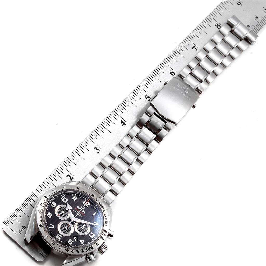 The image shows an Omega Speedmaster 321.10.44.50.01.001 Men
s Stainless Steel Black Dial 321.10.44.50.01.001 Men
s Stainless Steel Black Dial watch, with the face, bezel, and stainless steel bracelet, measured against a ruler.
