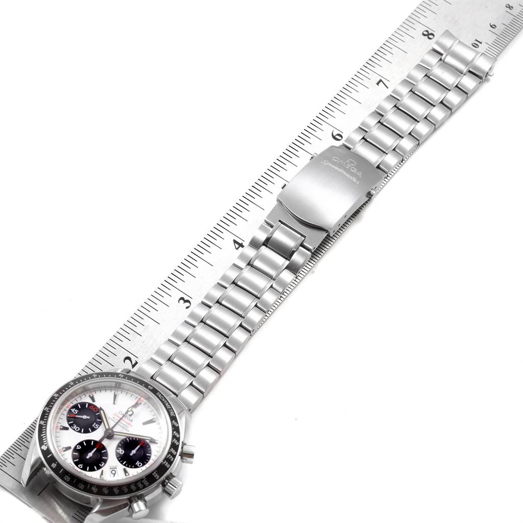 The image shows an Omega Speedmaster 323.30.40.40.04.001 Men
s Stainless Steel White Dial 323.30.40.40.04.001 Men
s Stainless Steel White Dial watch from a top-down angle alongside a ruler, highlighting the watch and its metal bracelet.