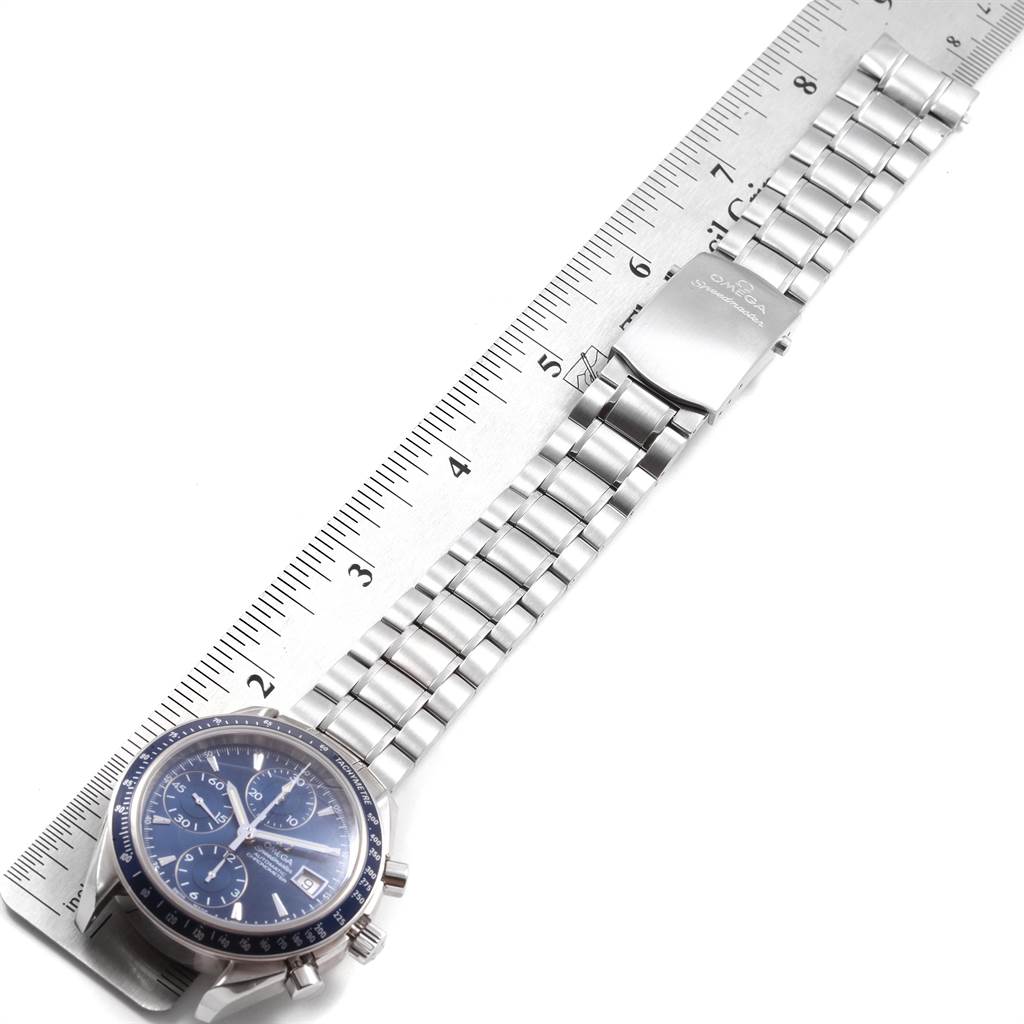 The image shows an Omega Speedmaster 3212.80.00 Men
s Stainless Steel Blue Dial 3212.80.00 Men
s Stainless Steel Blue Dial watch laid flat on a ruler, highlighting the face and full bracelet.