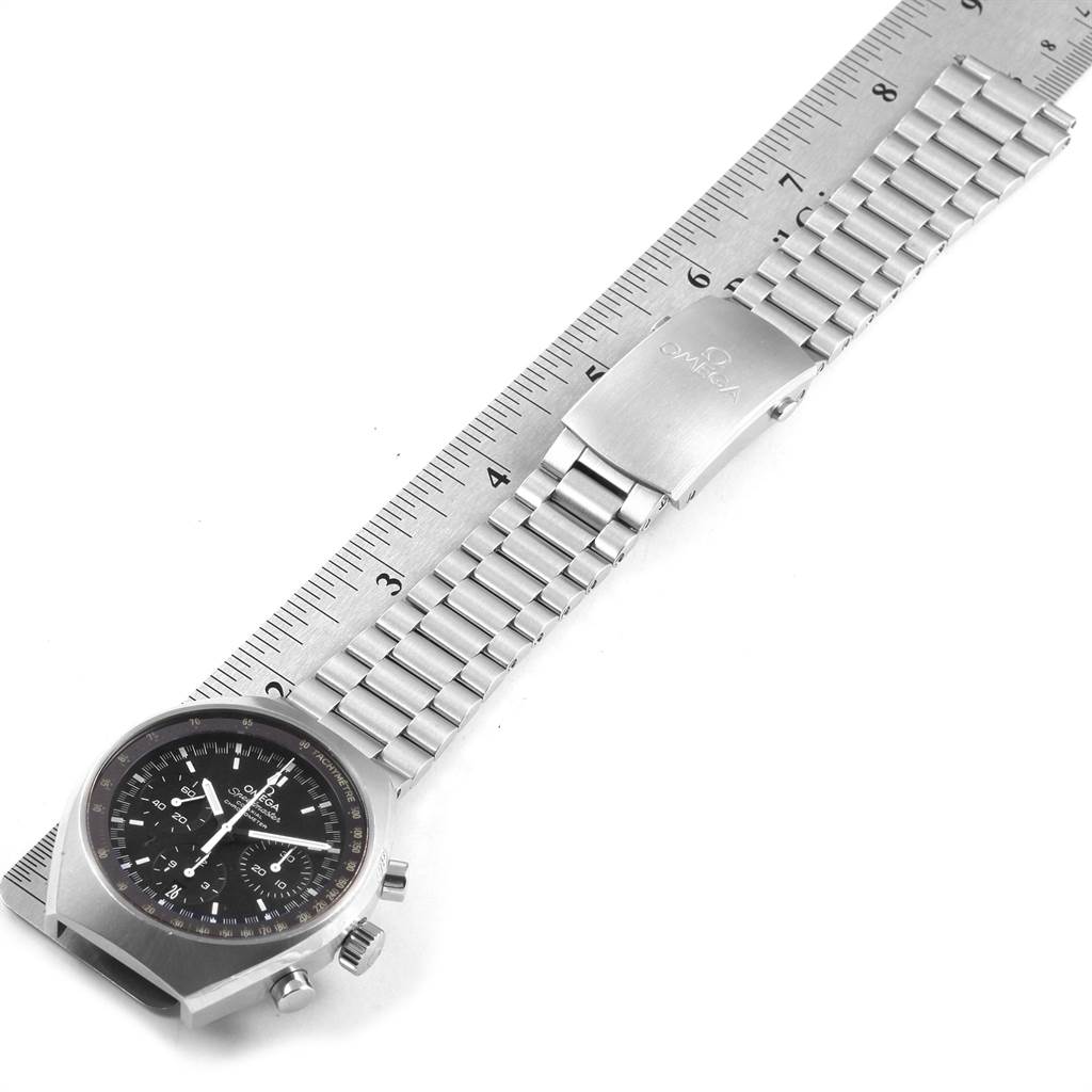 The image shows an Omega Speedmaster 327.10.43.50.01.001 Men
s Stainless Steel Black Dial 327.10.43.50.01.001 Men
s Stainless Steel Black Dial watch laid flat next to a ruler, highlighting the stainless steel bracelet and clasp.