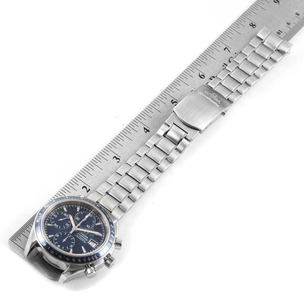 The image shows an Omega Speedmaster 3212.80.00 Men
s Stainless Steel Blue Dial 3212.80.00 Men
s Stainless Steel Blue Dial watch laid flat next to a ruler, displaying the face, bracelet, and clasp.