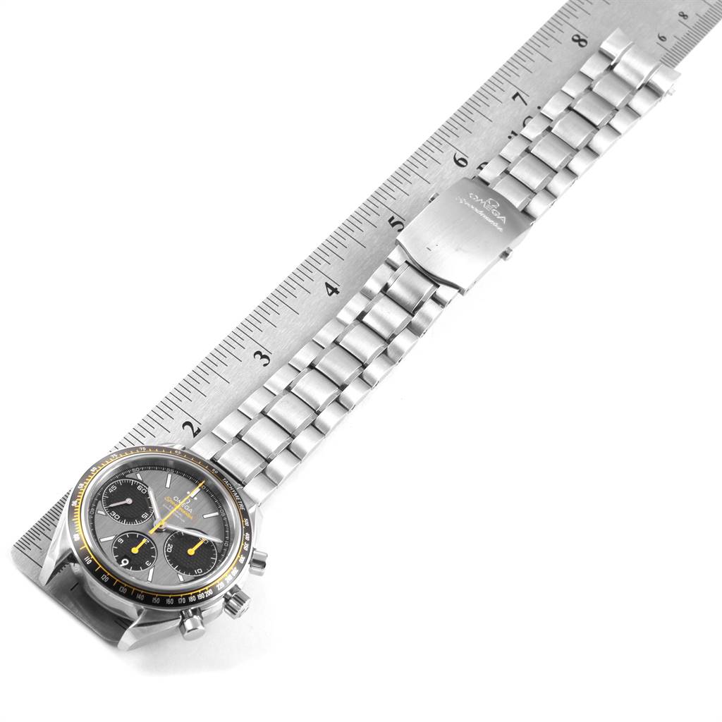 The image shows an Omega Speedmaster 326.30.40.50.06.001 Men
s Stainless Steel Grey Dial 326.30.40.50.06.001 Men
s Stainless Steel Grey Dial watch laid flat next to a ruler, highlighting the dial and metal bracelet.