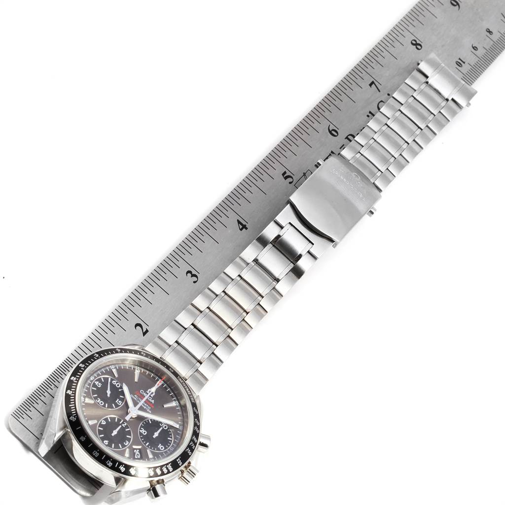 The image shows an Omega Speedmaster 323.30.40.40.06.001 Men
s Stainless Steel Grey Dial 323.30.40.40.06.001 Men
s Stainless Steel Grey Dial watch laid flat next to a ruler, displaying the face and metal bracelet.