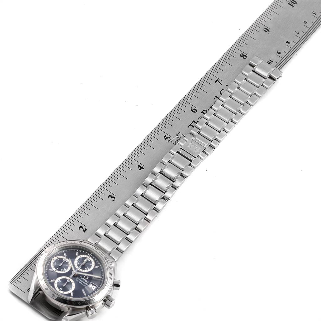 The image shows an Omega Speedmaster 3513.46.00 Men
s Stainless Steel Blue Dial 3513.46.00 Men
s Stainless Steel Blue Dial watch positioned next to a ruler, displaying the dial and metal bracelet.