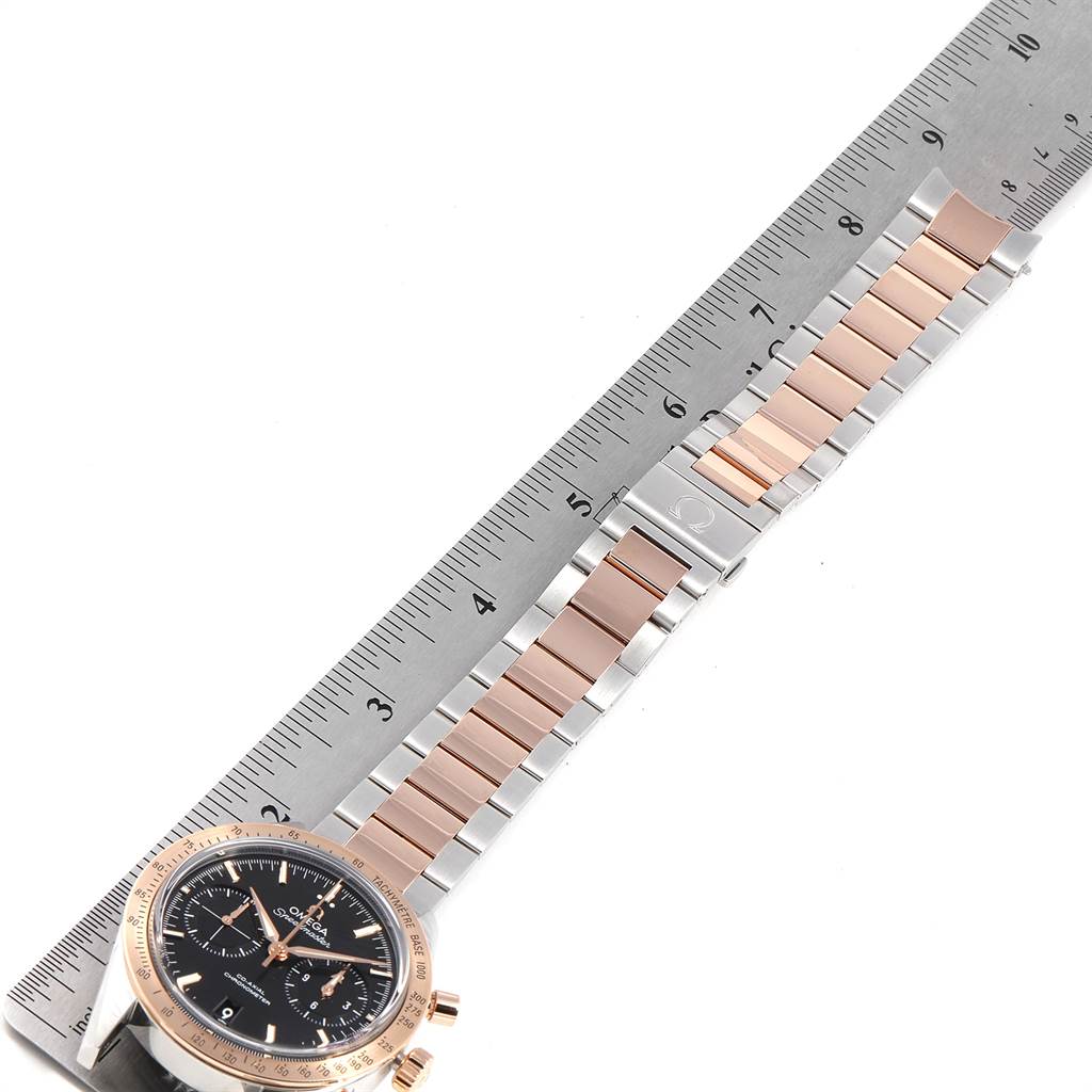 The image shows an Omega Speedmaster 331.20.42.51.01.002 Men's Steel and Gold (two tone) Black Dial 331.20.42.51.01.002 Men's Steel and Gold (two tone) Black Dial watch with its bracelet extended alongside a ruler for measurement.
