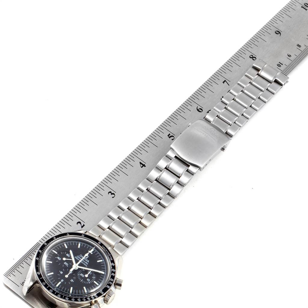 The image shows an Omega Speedmaster 3570.50.00 Men
s Stainless Steel Black Dial 3570.50.00 Men
s Stainless Steel Black Dial watch laid flat, alongside a ruler, displaying its bracelet and clasp.