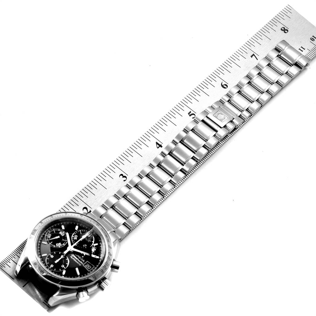 The image shows an Omega Speedmaster 3513.50.00 Men
s Stainless Steel Black Dial 3513.50.00 Men
s Stainless Steel Black Dial watch laid next to a ruler, displaying the watch face and metal bracelet.