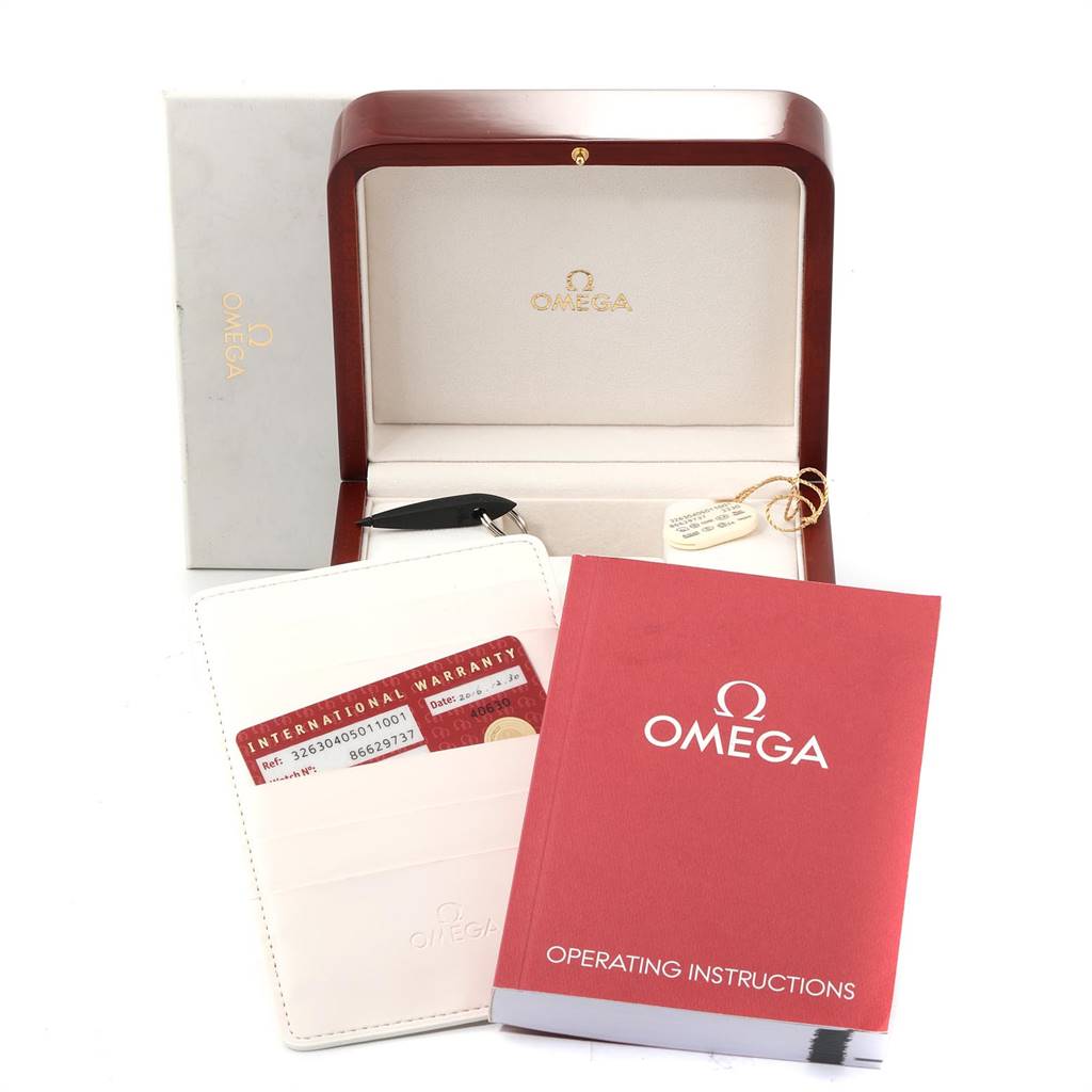 The image shows an Omega Speedmaster 326.30.40.50.11.001 Men's Stainless Steel Red Dial 326.30.40.50.11.001 Men's Stainless Steel Red Dial watch box, international warranty card holder, and operating instructions from a frontal angle.