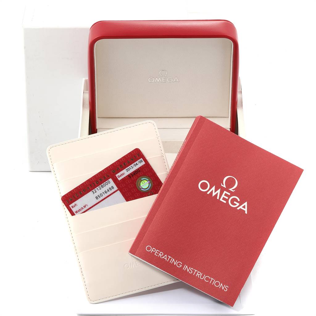 The image includes the Omega Speedmaster 3212.80.00 Men's Stainless Steel Blue Dial 3212.80.00 Men's Stainless Steel Blue Dial watch's box, manuals, and warranty card holder viewed from an overhead angle.