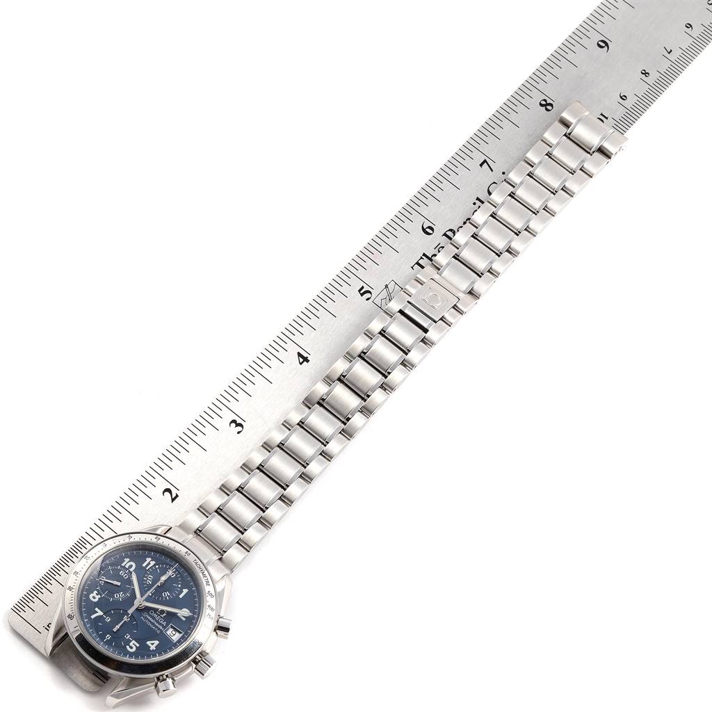 The Omega Speedmaster 3513.82.00 Men
s Stainless Steel Blue Dial 3513.82.00 Men
s Stainless Steel Blue Dial watch, shown from a top view, features the face and metal bracelet displayed alongside a ruler for measurement.