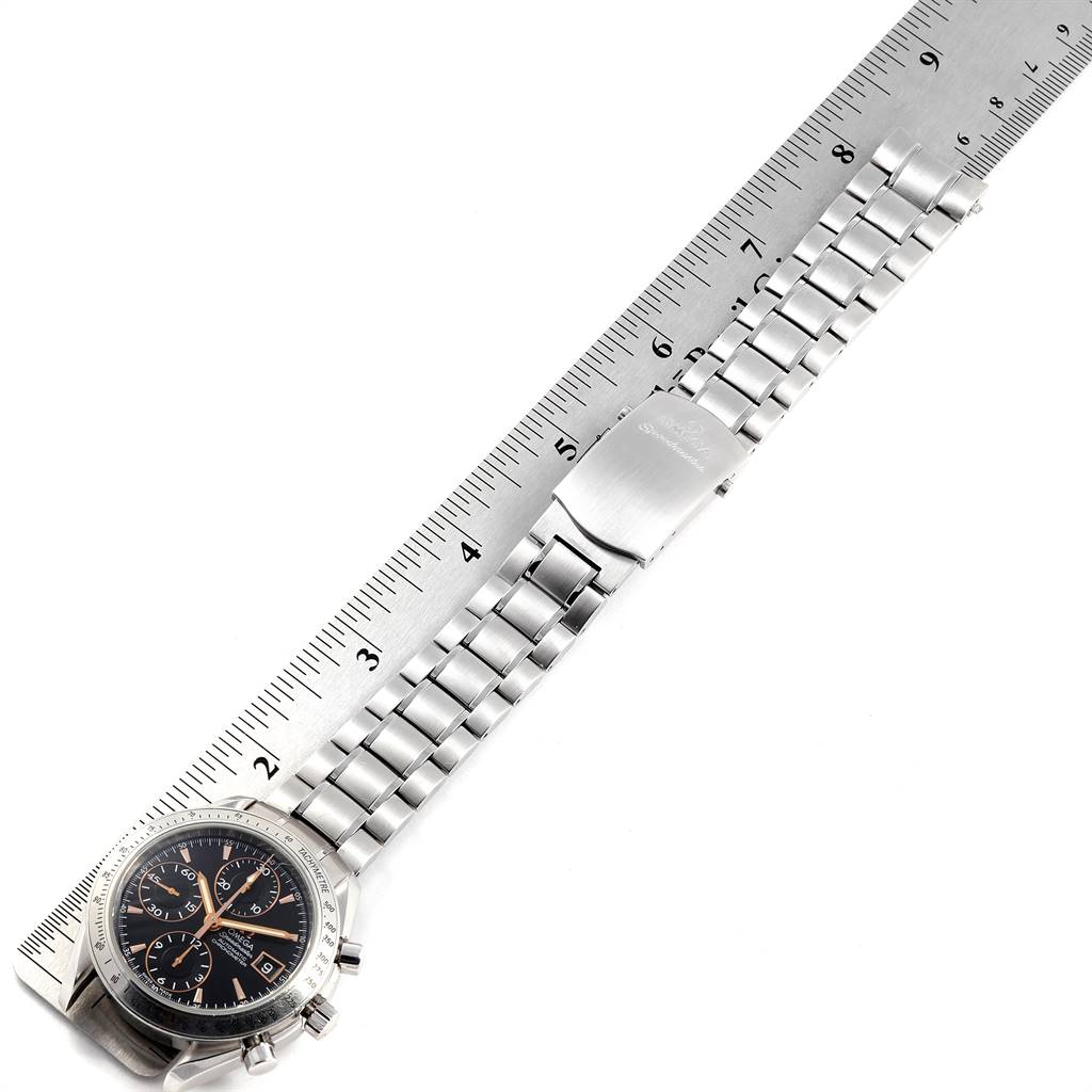 The image shows an Omega Speedmaster 3211.50.00 Men
s Stainless Steel Black Dial 3211.50.00 Men
s Stainless Steel Black Dial watch laid flat with its bracelet fully extended next to a ruler for size indication.