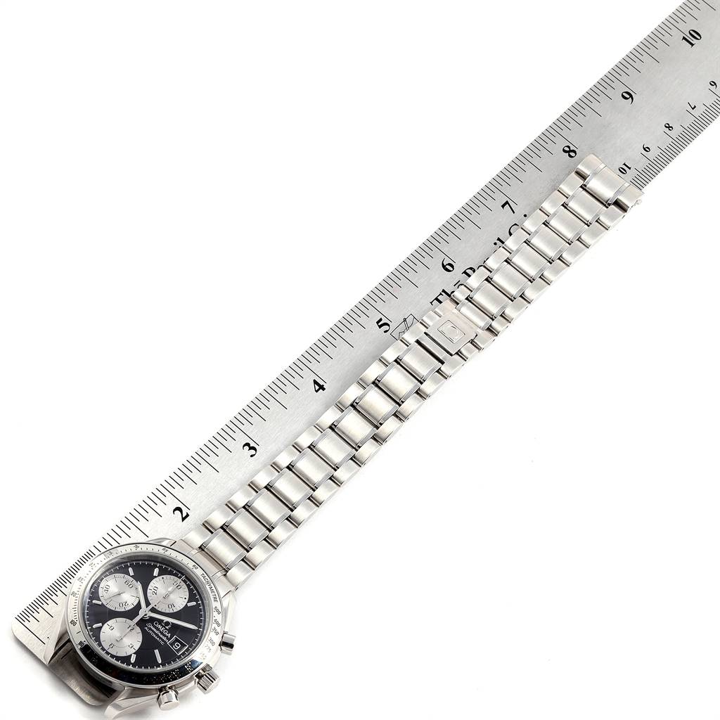 The image shows the Omega Speedmaster 3513.51.00 Men
s Stainless Steel Black Dial 3513.51.00 Men
s Stainless Steel Black Dial watch laid flat next to a ruler, highlighting its strap and dial.