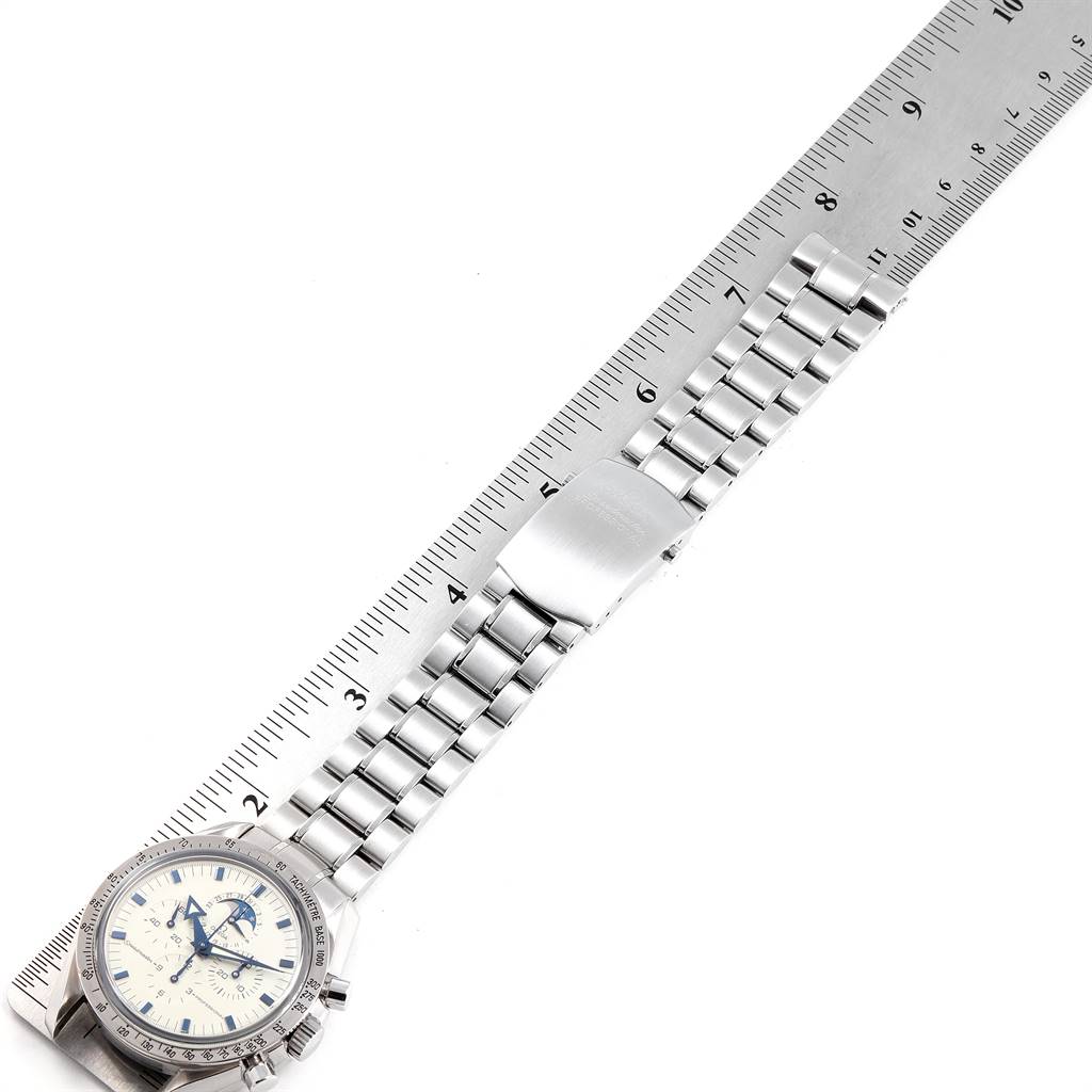 The Omega Speedmaster 3575.20.00 Men
s Stainless Steel White Dial 3575.20.00 Men
s Stainless Steel White Dial watch is shown from a top-down angle, displaying the face, bracelet, and clasp alongside a ruler for scale.