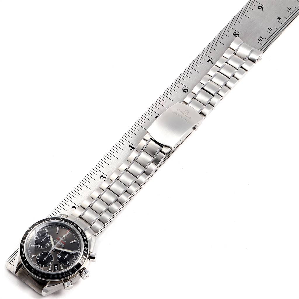 The image shows an Omega Speedmaster 323.30.40.40.06.001 Men
s Stainless Steel Grey Dial 323.30.40.40.06.001 Men
s Stainless Steel Grey Dial watch laid flat next to a ruler, highlighting its bracelet and clasp.