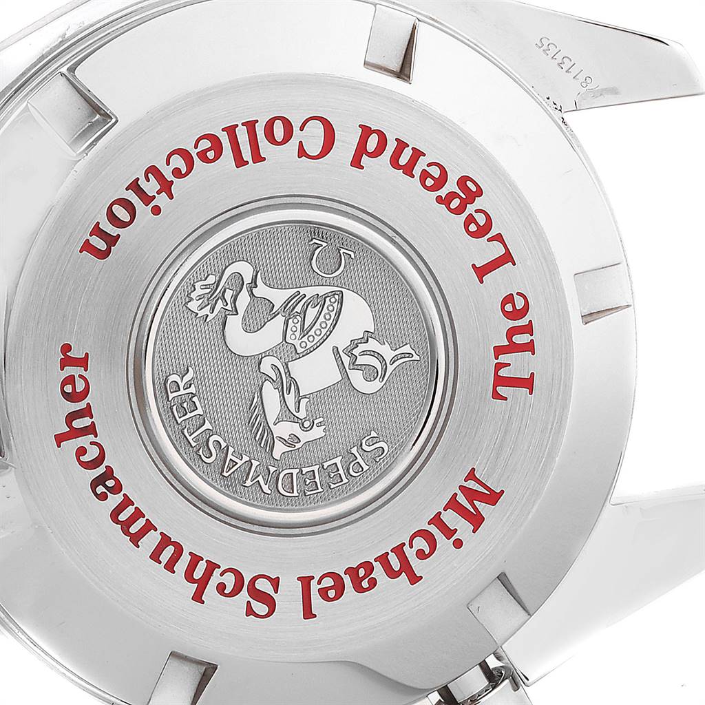 The image shows the case back of an Omega Speedmaster 3506.61.00 Men's Stainless Steel Red Dial 3506.61.00 Men's Stainless Steel Red Dial Michael Schumacher Legend Collection watch, featuring engravings and a medallion.
