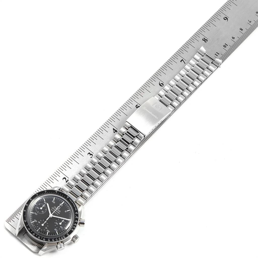 The Omega Speedmaster 3510.50.00 Men
s Stainless Steel Black Dial 3510.50.00 Men
s Stainless Steel Black Dial watch is shown lying flat next to a ruler displaying its metal bracelet and clasp.