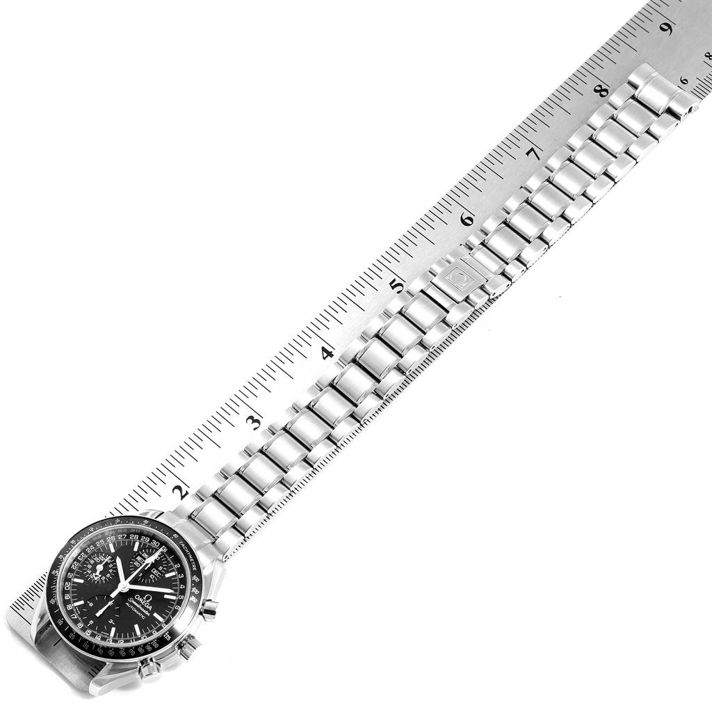 The Omega Speedmaster 3520.50.00 Men
s Stainless Steel Black Dial 3520.50.00 Men
s Stainless Steel Black Dial watch is shown from a top-down angle, with the entire watch and bracelet laid out alongside a ruler.