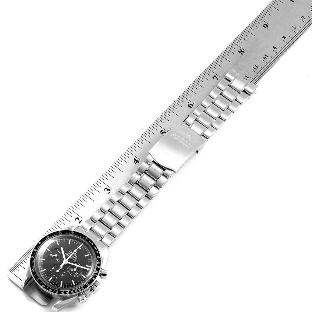 The image shows the Omega Speedmaster 145.0022 Men
s Stainless Steel Black Dial 145.0022 Men
s Stainless Steel Black Dial watch placed next to a ruler, highlighting its metal bracelet and clasp.