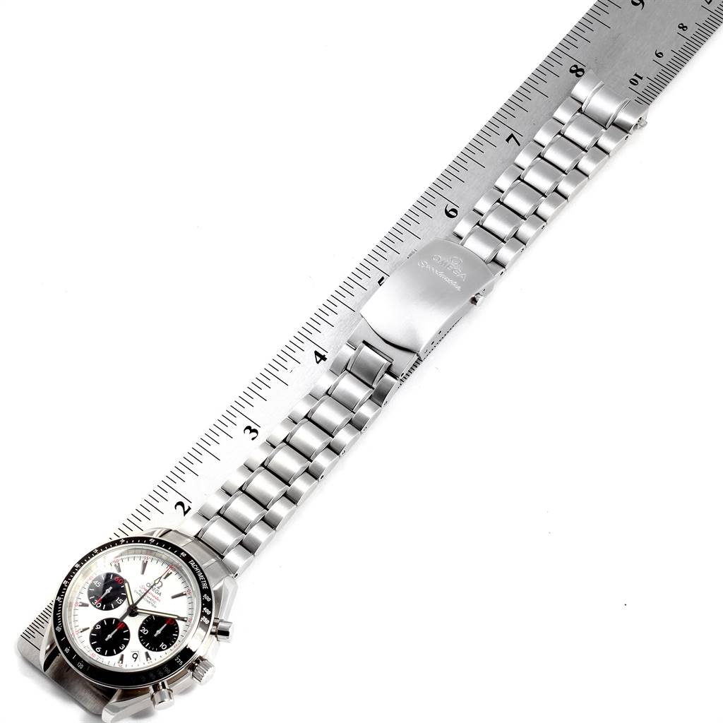 The image shows an Omega Speedmaster 323.30.40.40.04.001 Men
s Stainless Steel White Dial 323.30.40.40.04.001 Men
s Stainless Steel White Dial watch resting diagonally beside a ruler, displaying its stainless steel bracelet and clasp.