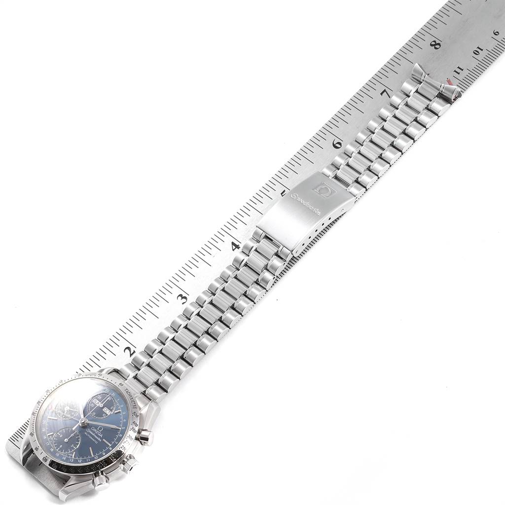 The image shows an Omega Speedmaster 3521.80.00 Men
s Stainless Steel Blue Dial 3521.80.00 Men
s Stainless Steel Blue Dial watch laid flat with its metal bracelet beside a ruler for scale.