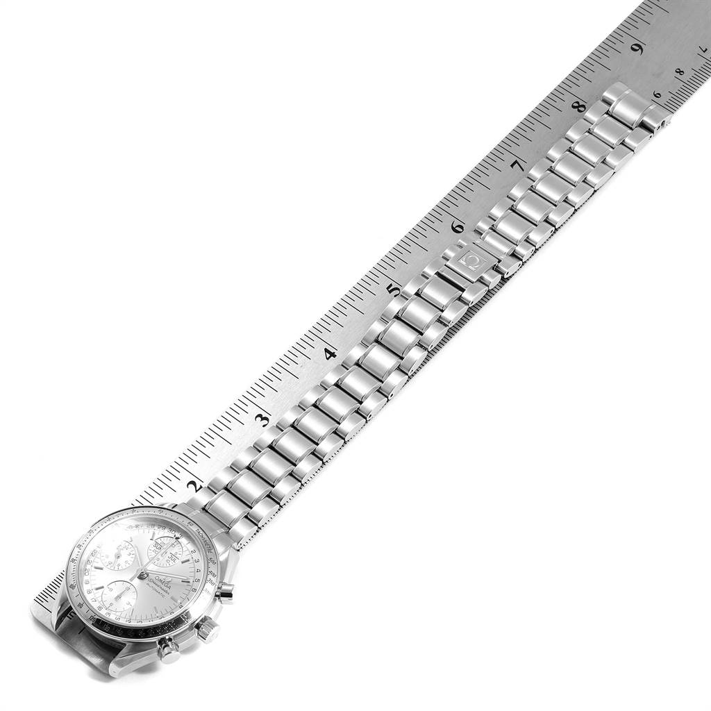 The Omega Speedmaster 3523.30.00 Men
s Stainless Steel Silver Dial 3523.30.00 Men
s Stainless Steel Silver Dial watch is shown at an angle, laying flat, with its metal bracelet and face visible alongside a measuring ruler.