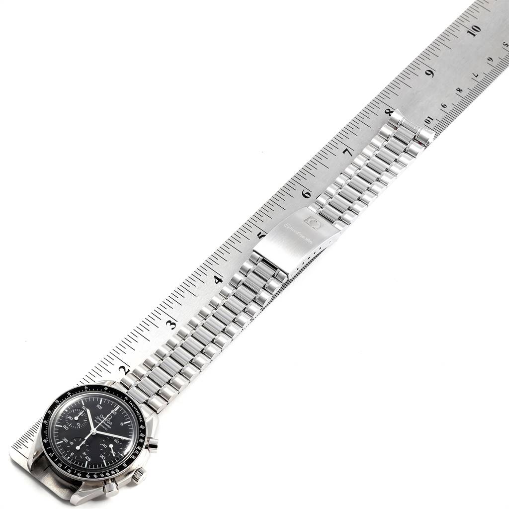 The Omega Speedmaster 3510.50.00 Men
s Stainless Steel Black Dial 3510.50.00 Men
s Stainless Steel Black Dial watch is shown from a top-down angle with the strap extended alongside a ruler.