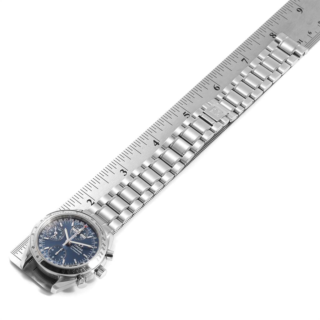 The image shows an Omega Speedmaster 3523.80.00 Men
s Stainless Steel Blue Dial 3523.80.00 Men
s Stainless Steel Blue Dial watch angled diagonally with its metal bracelet measured against a ruler.