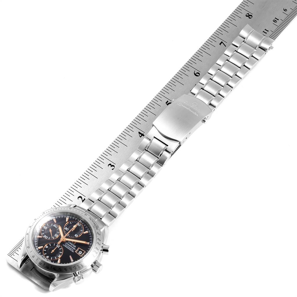 The image shows an Omega Speedmaster 3211.50.00 Men
s Stainless Steel Black Dial 3211.50.00 Men
s Stainless Steel Black Dial watch laid flat and measured with a ruler, highlighting both the watch face and metal bracelet.