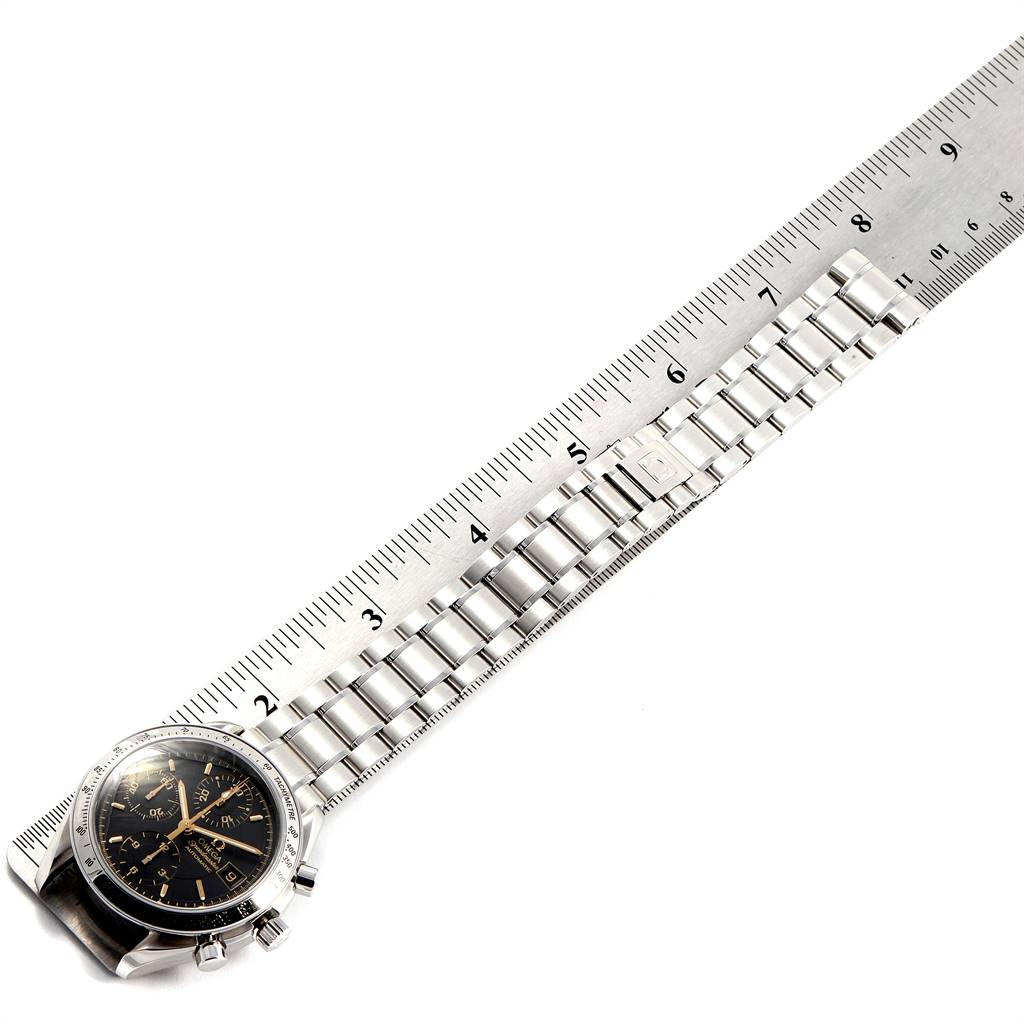 The Omega Speedmaster 3513.54.00 Men's Stainless Steel Black Dial 3513.54.00 Men's Stainless Steel Black Dial watch is displayed flat with its metal bracelet laid out next to a ruler for measurement.