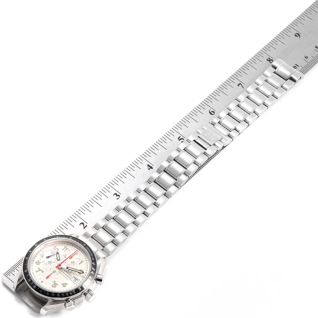 The image shows an Omega Speedmaster 3513.33.00 Men's Stainless Steel White Dial 3513.33.00 Men's Stainless Steel White Dial watch with its face and metal bracelet laid beside a ruler for measurement.