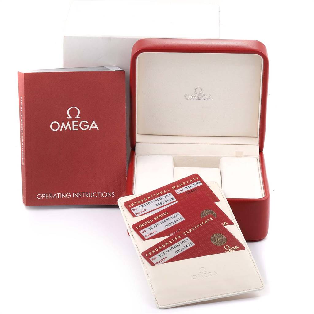 The image shows the Omega Speedmaster 323.30.40.40.01.001 Men
s Stainless Steel Black Dial 323.30.40.40.01.001 Men
s Stainless Steel Black Dial
s red operating instructions booklet, warranty cards, and an open watch box without the watch.